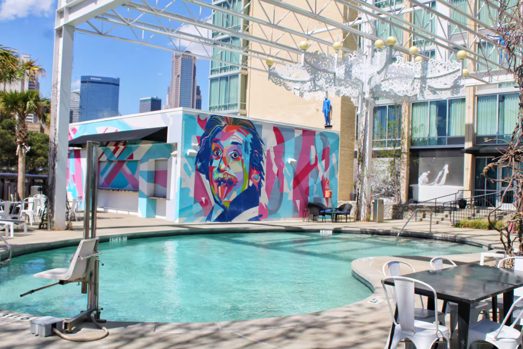 Outdoor pool area with large-scale art mural at The Lorenzo Hotel