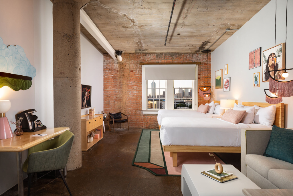 Loft-style guest room with exposed brick at Canvas Hotel Dallas