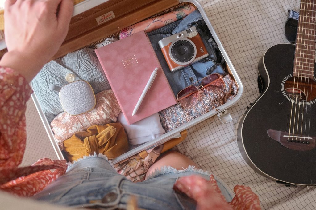 Traveler organizing clothes and gear in suitcase