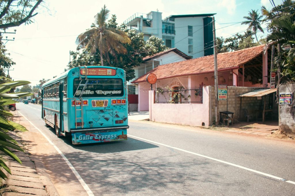 Blue public bus on a sunny coastal road in Sri Lanka near Galle